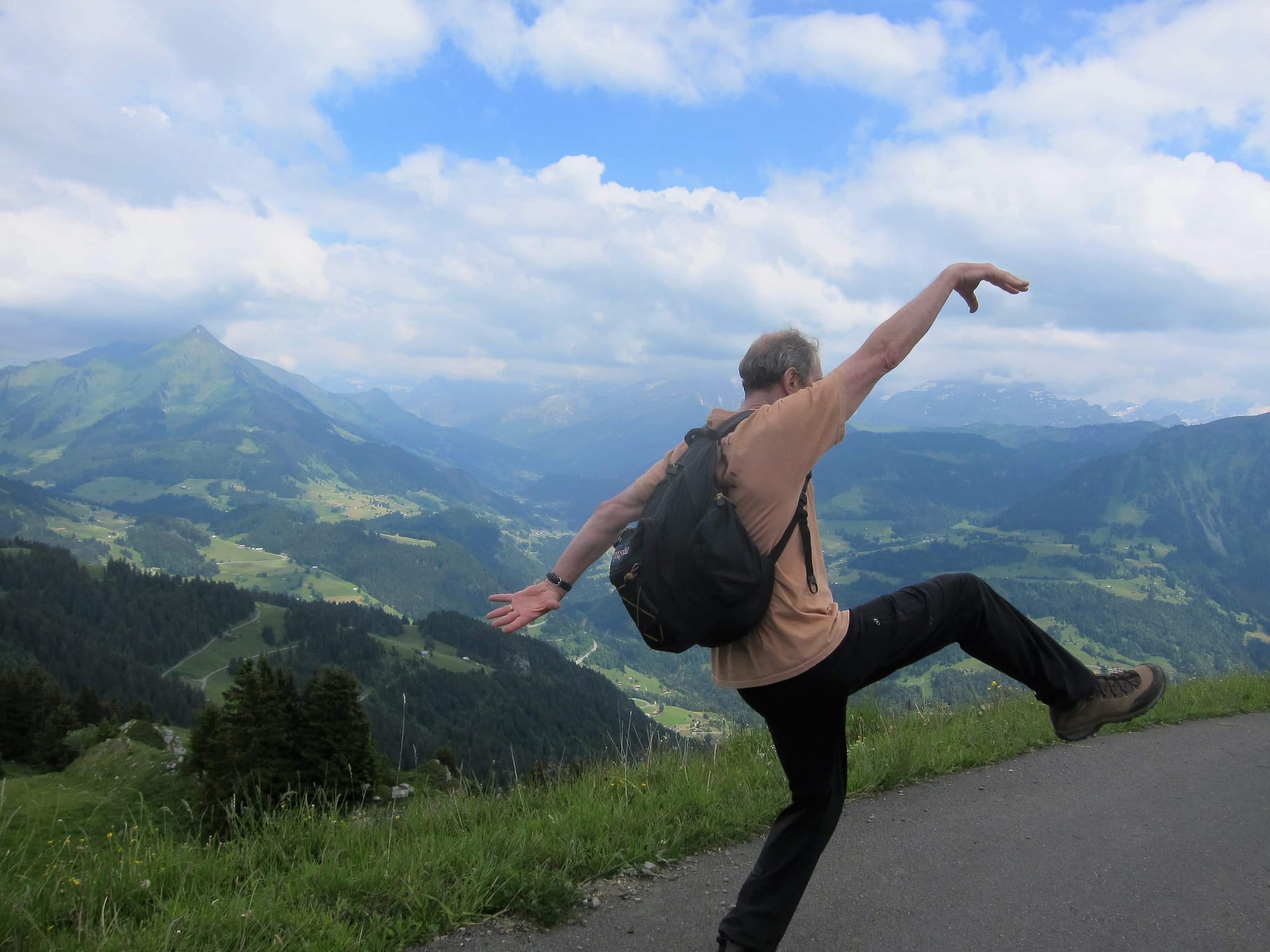 Gary J. Kirchner striking a pose on a mountain road above an alpine valley